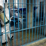 En la foto una persona con protección sanitaria se encuentra sanitizando las celdas de una cárcel en Ciudad de México
