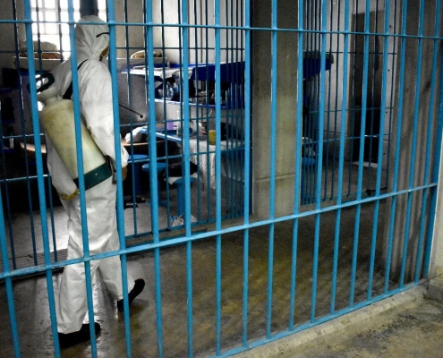 En la foto una persona con protección sanitaria se encuentra sanitizando las celdas de una cárcel en Ciudad de México