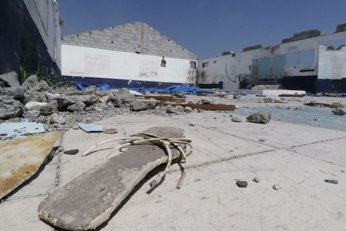 Una sandalia de mujer en el piso en medio de las ruinas de un edificio