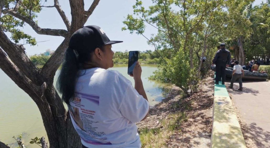 Una mujer sostiene su celular grabando a la Guardia Nacional en una playa