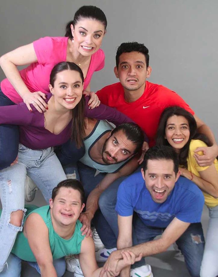 En la imagen varias personas jovenes se abrazan con camisetas de diferentes colores